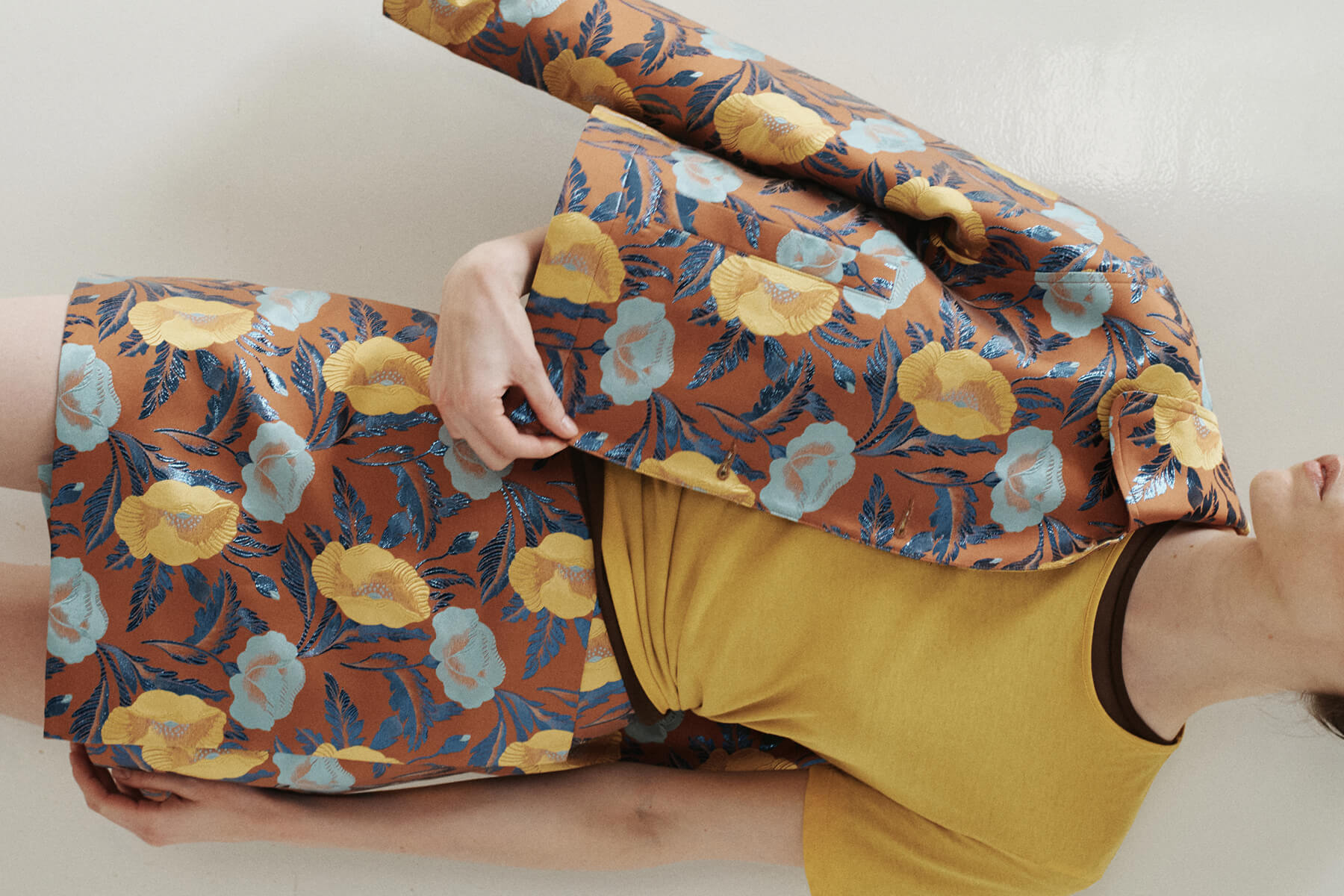 Close up of floral jacket and matching skirt, with yellow tee, side view.