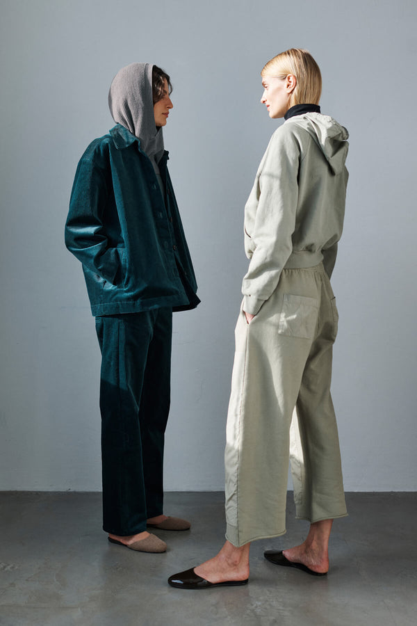 Two women standing facing each other in Sam Spruce set with hoodie, and Sage Jamie sweatsuit set.