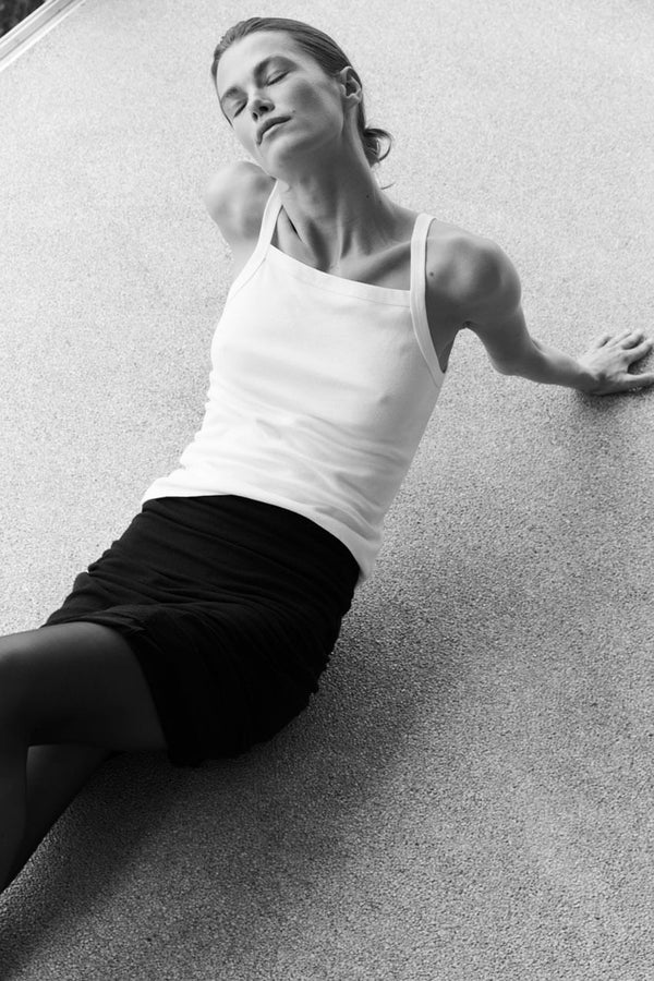 Woman sitting on floor in nando white tank