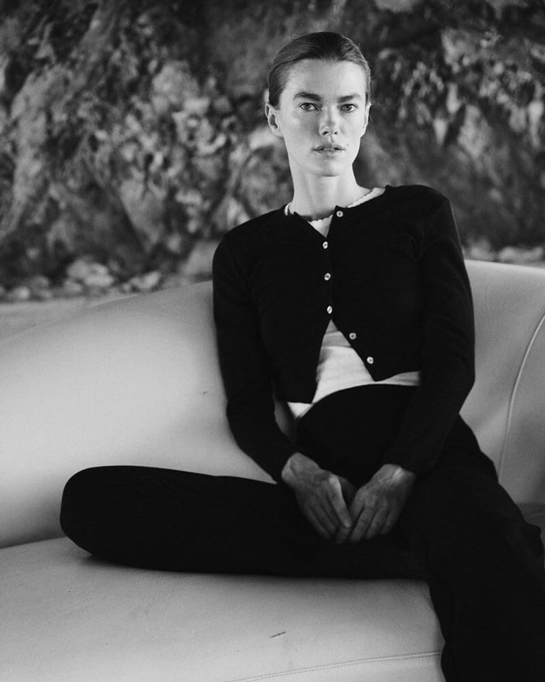 Woman in Pointelle black cardigan sitting on white couch
