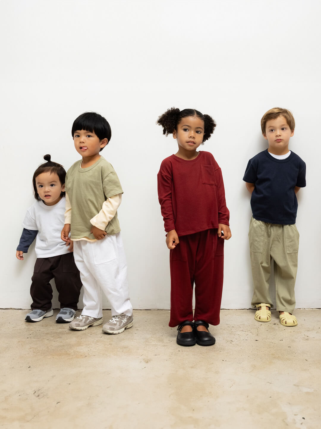 Kids in LESET Bebe Sets standing against wall together