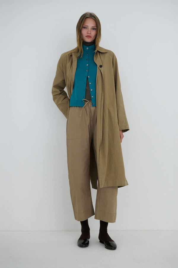 Woman in Kyoto Coat and matching birch pants, with James caribbean cardigan standing against white background.