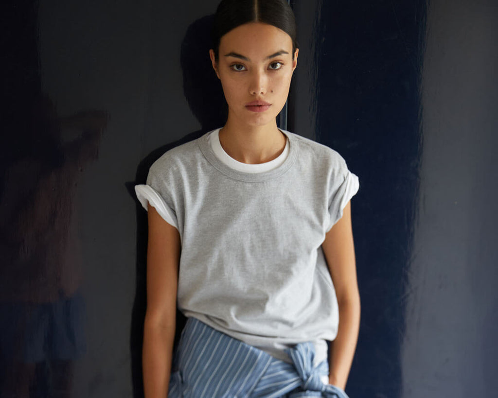 Woman in grey Margo T-shirt layered over white Tee