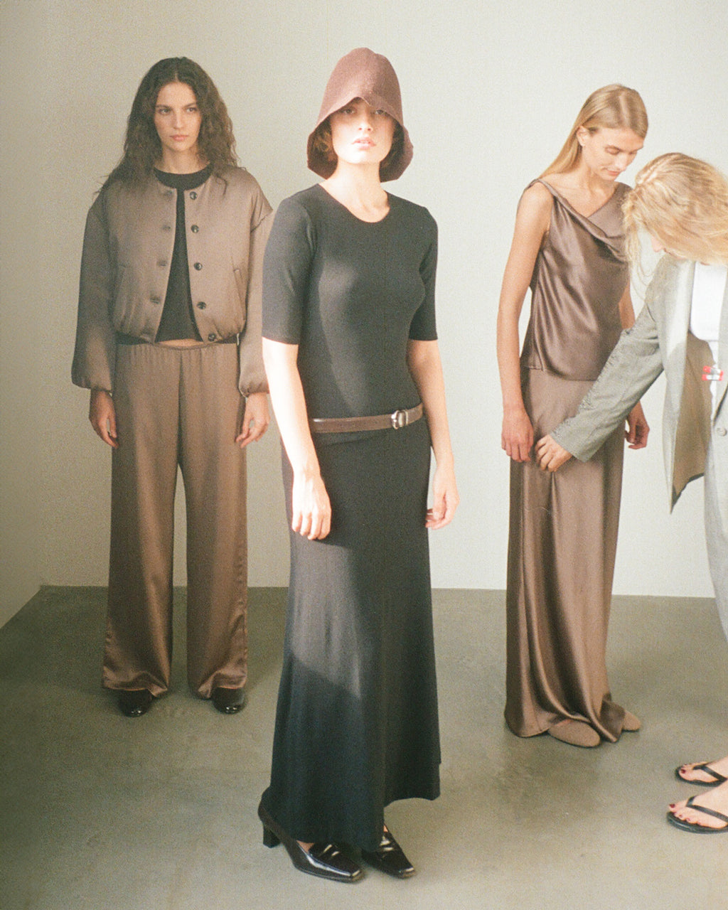 Women standing looking off into distance, in Barb satin set, Lauren charcoal set.