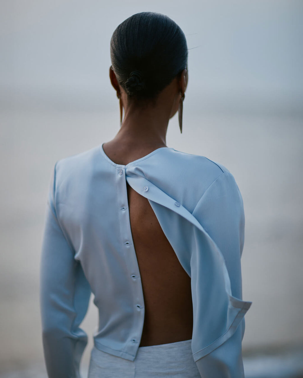 back of woman in powder blue barb cardigan