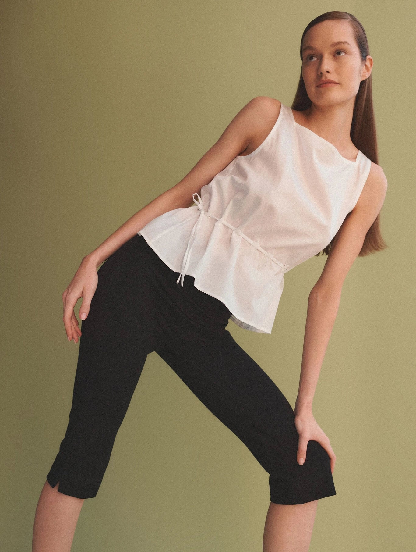 Woman posing in Rio Capri with white drawstring top, side angle.