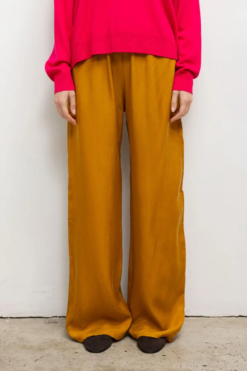 Close up of model wearing the Kim pocket pant in orange.