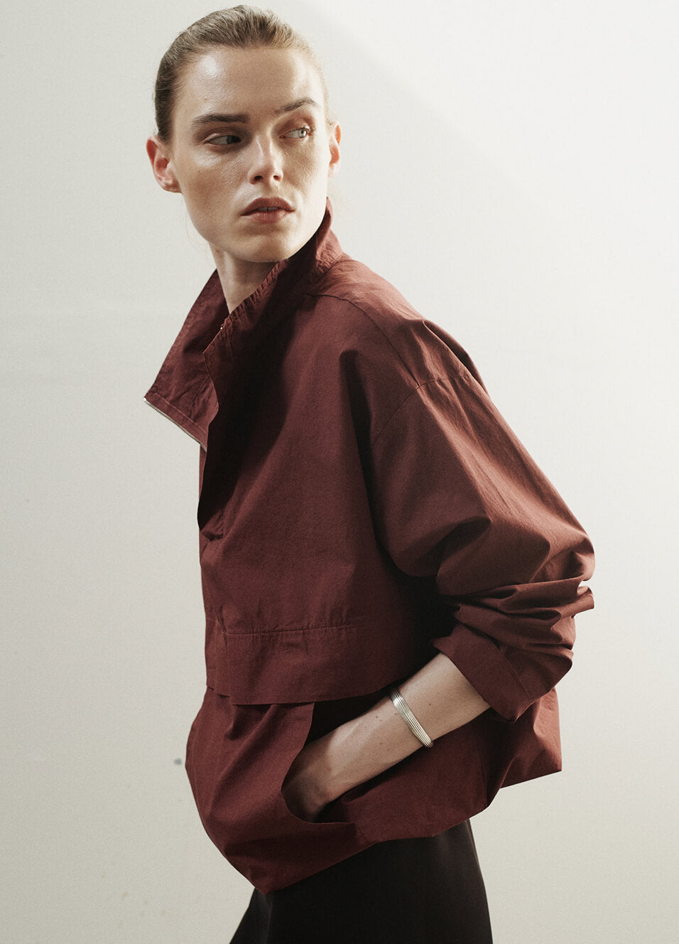 Woman in maroon Kyoto jacket, looking to the side.