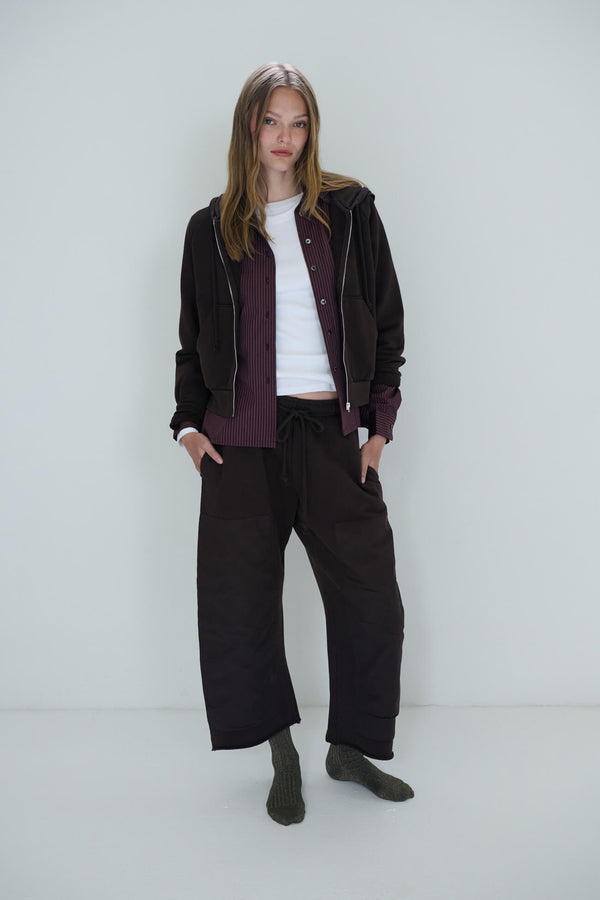 Woman standing in chocolate jamie sweatsuit layered over white tee and yoshi button down
