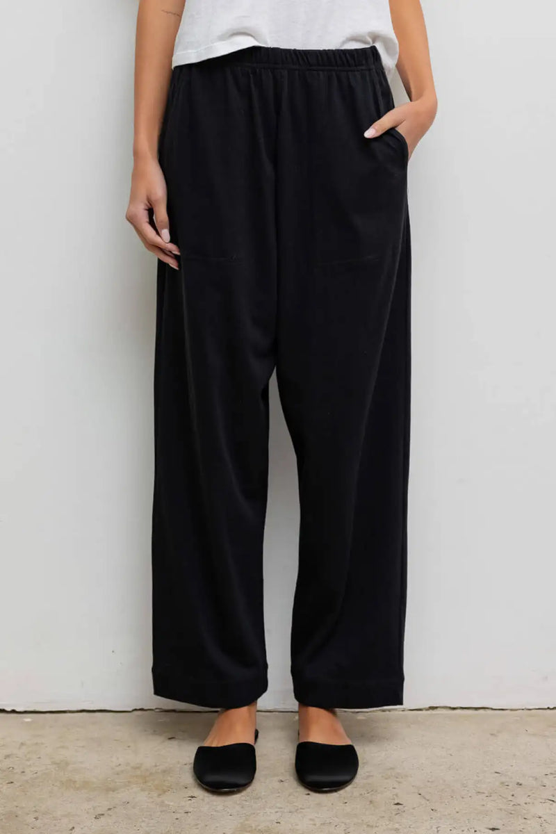 Close up of model wearing the Margo tapered pocket pant in black.