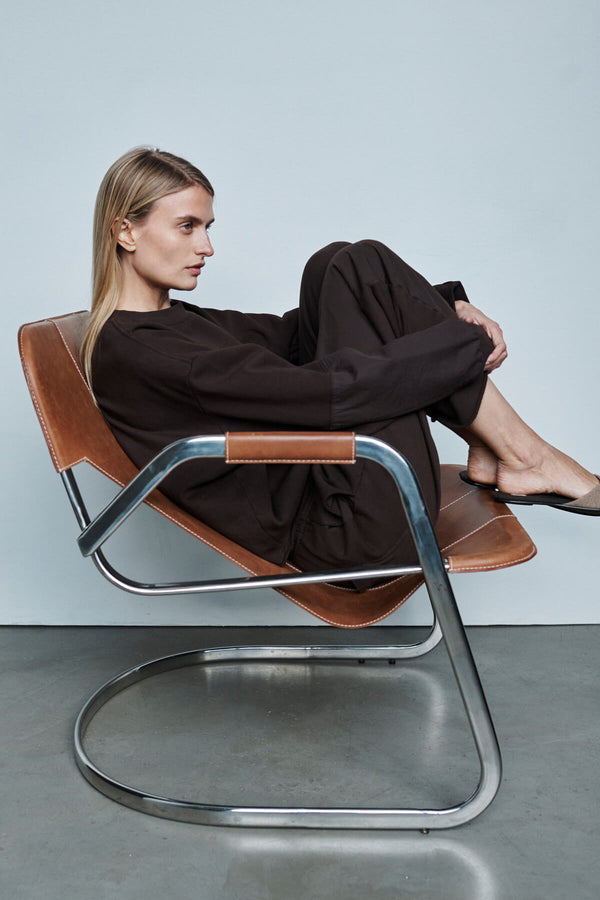 Woman sitting on chair in chocolate Jamie sweatsuit set.