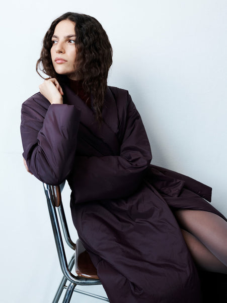 Woman sitting on chair in bordeaux trench and tights with Ruby Romy Mules