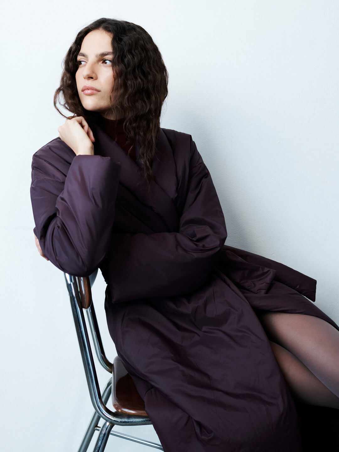 Woman sitting on chair in bordeaux trench and tights with Ruby Romy Mules