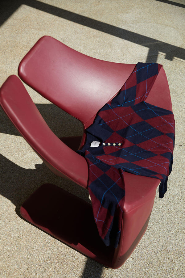 James Argyle Polo draped over bordeaux colored chair