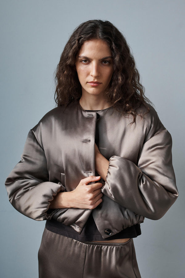 Woman standing in Barb Taupe Bomber jacket looking into the distance