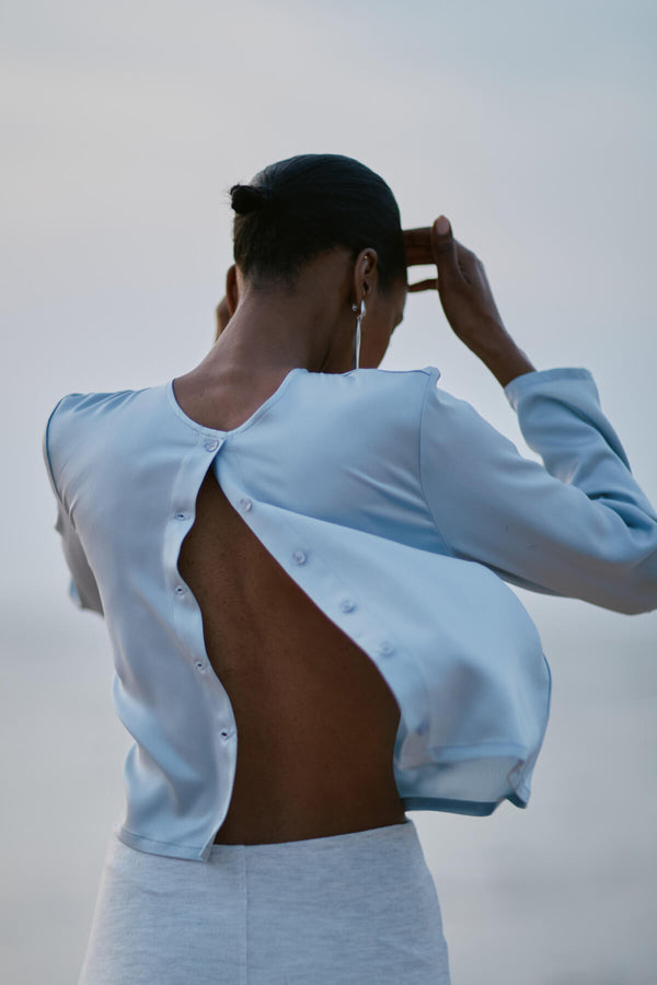 Back of Woman in Satin Powder colored Barb Crew Cardigan  looking down